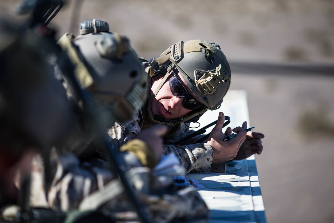 A Marine with 3rd Reconnaissance Battalion, 3rd Marine Division, 3rd Marine Expeditionary Force explains how to call in a 9 line at Marine Corps Air Ground Combat Center, Twentynine Palms, Calif,. Jan. 23, 2018, as a part of Integrated Training Exercise 2-18. The purpose of ITX is to create a challenging, realistic training environment that produces combat-ready forces capable of operating as an integrated MAGTF. (U.S. Marine Corps Photo by Pfc. William Chockey)