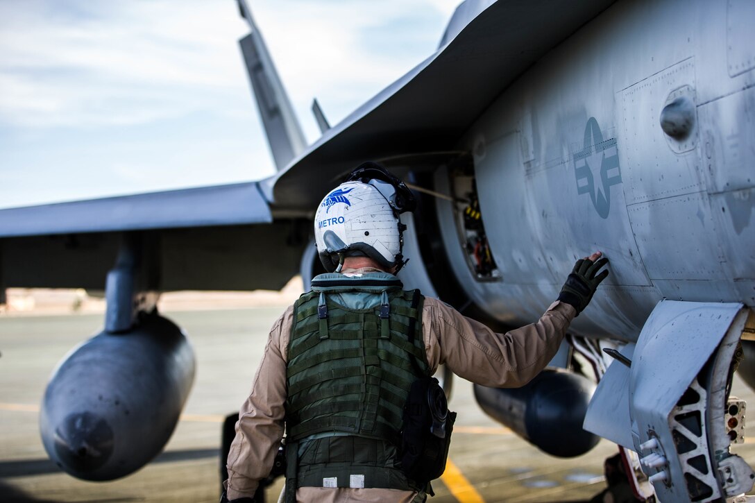 A Marine with Marine Fighter Attack Squadron All-Weather 225 does a pre-flight check of a F-18 at the Air Combat Element landing strip aboard the Marine Corps Air Ground Combat Center, Twentynine Palms, Calif., Jan. 26, 2018, as a part of Integrated Training Exercise 2-18. The purpose of ITX is to create a challenging, realistic training environment that produces combat-ready forces capable of operating as an integrated MAGTF. (U.S. Marine Corps Photo by Pfc. William Chockey)