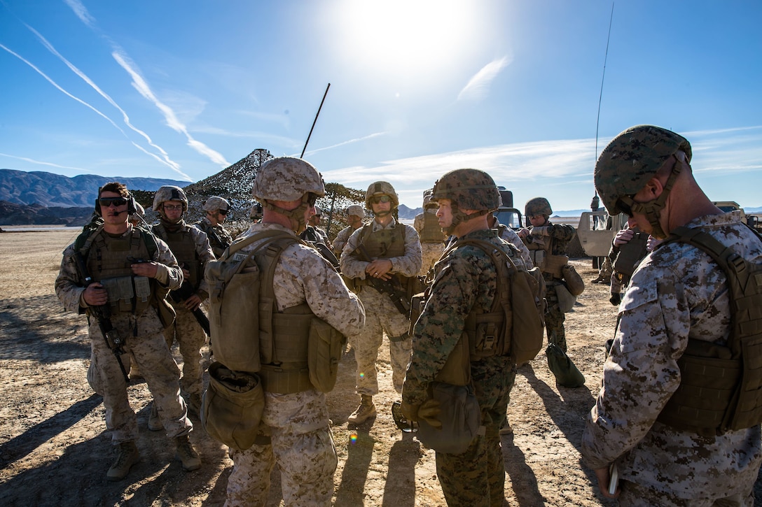 Marines with Special Purpose Marine Air Ground Task Force 5 talk with Marines from Marine Wing Support Squadron 371 at a  Forward Arming and Refueling Point at Marine Corps Air Ground Combat Center, Twentynine Palms, Calif., Feb. 4, 2018, as a part of Integrated Training Exercise 2-18. The purpose of ITX is to create a challenging, realistic training environment that produces combat-ready forces capable of operating as an integrated MAGTF. (U.S. Marine Corps Photo by Pfc. William Chockey)