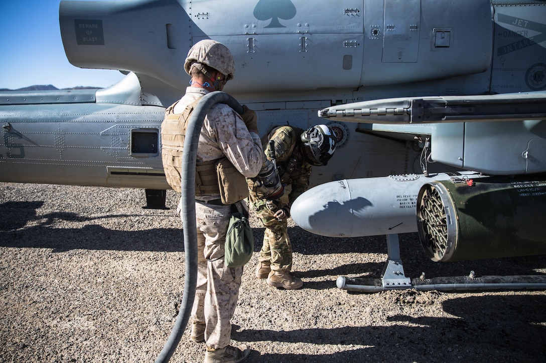 A Marine with Marine Wing Support Squadron 371 carries a jet fuel line to a Bell AH-1Z Viper at Marine Corps Air Ground Combat Center, Twentynine Palms, Calif., Feb. 4, 2018, as a part of Integrated Training Exercise 2-18. The purpose of ITX is to create a challenging, realistic training environment that produces combat-ready forces capable of operating as an integrated MAGTF. (U.S. Marine Corps Photo by Pfc. William Chockey)