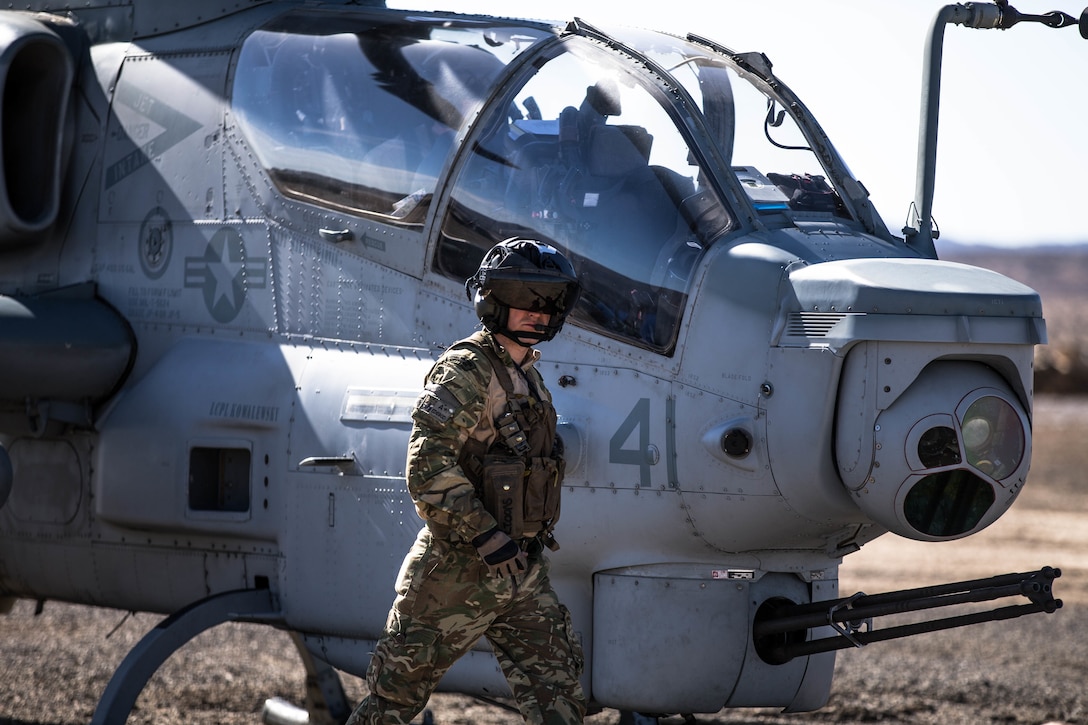 A Royal Marines Commando prepares to get into a Bell AH-1Z Viper at a Forward Arming and Refueling Point at Marine Corps Air Ground Combat Center, Twentynine Palms, Calif., Feb. 4, 2018, as a part of Integrated Training Exercise 2-18. The purpose of ITX is to create a challenging, realistic training environment that produces combat-ready forces capable of operating as an integrated MAGTF. (U.S. Marine Corps Photo by Pfc. William Chockey)