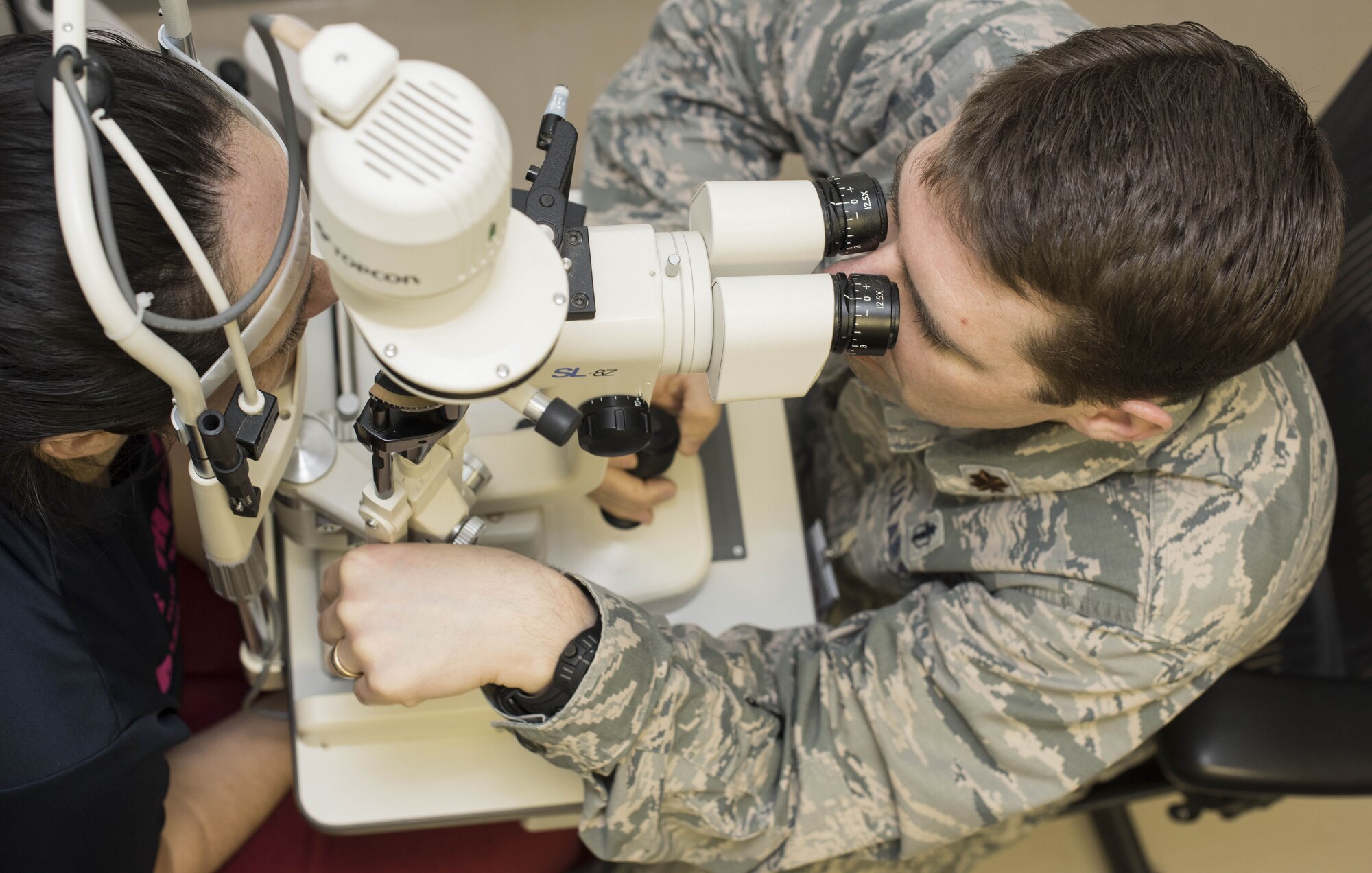 Maj. Ethan Woodbury, 35th Aerospace Medicine Squadron optometry flight commander, uses a phoropter to examine a patients eyes at Misawa Air Base, Japan, Feb. 7, 2018. The phoropter is used for routine exams during sight testing and can determine an individual’s prescription. Optometrists are one specialty of the 18 in the Biomedical Sciences Corps. (U.S. Air Force photo by Airman Xiomara M. Martinez)