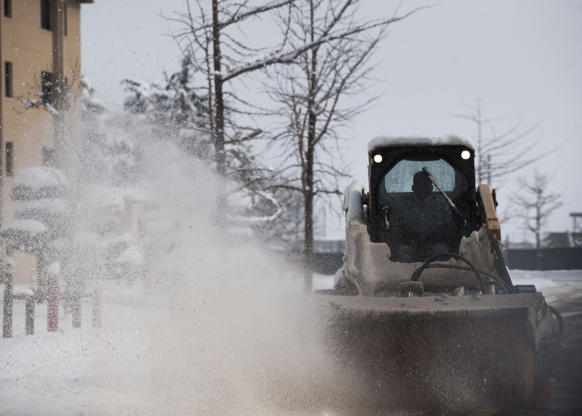 An Airman assigned to the 8th Civil Engineer Squadron operates a snow plow to clear the roads around the installation at Kunsan Air Base, Republic of Korea, Jan. 11, 2018. During the second week of January more snow accumulated at Kunsan than in all of 2017, requiring snow removal teams to conduct 24-hour operations to maintain mission readiness.  (U.S. Air Force photo by Staff Sgt. Victoria H. Taylor)
