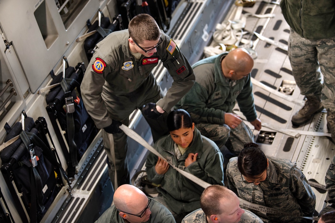 Air Force Senior Airman Austen Copeland assists airmen boarding a C-17 Globemaster III aircraft.