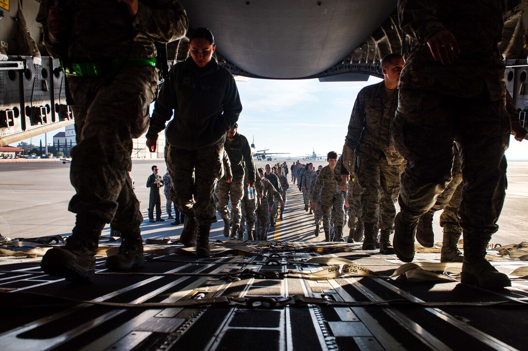 Airmen board a C-17 Globemaster III aircraft.