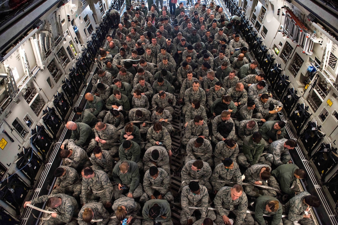 Airmen sit inside off a C-17 Globemaster III aircraft.