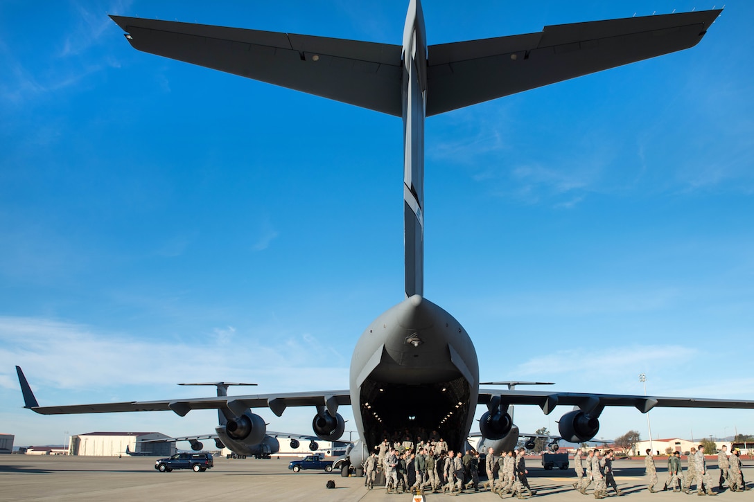 Airmen exit a C-17 Globemaster III aircraft during a readiness exercise.