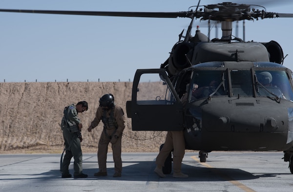 U.S. instructor pilots assist an Afghan Mi-17 pilot into a safety harness before his first orientation flight in the Afghan UH-60A Black Hawk Oct. 3, 2017, at Kandahar Airfield, Afghanistan. Mi-17 pilots are retraining to the Black Hawk and are expected to fly the aircraft by the end of 2017. The UH-60 is part of a multi-year modernization plan for the Afghan Air Force. (U.S. Air Force photo by Staff Sgt. Alexander W. Riedel)