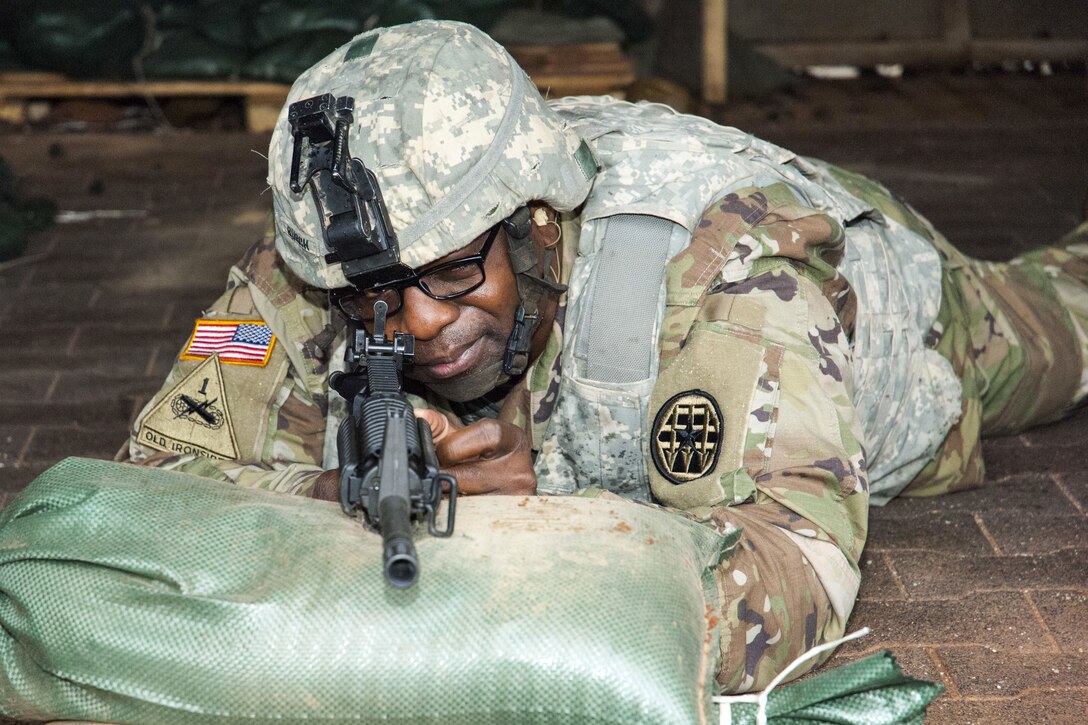 A soldier looks through the sights of his rifle.