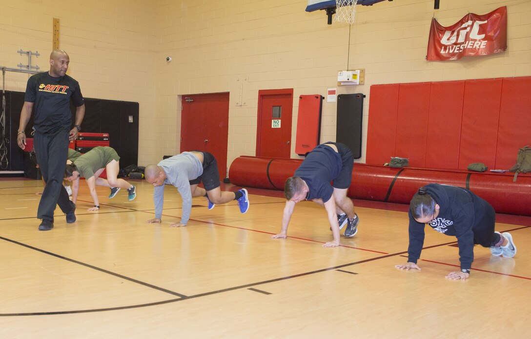 Marines from U.S. Marine Corps Forces Command and Marine Air Group 49, Marine Medium Tiltrotor Squadron 774, 4th Marine Aircraft Wing, do burpees while Christopher Harper, High Intensity Tactical Training coordinator, Semper Fit, monitors their technique during a HITT Level I instructor course  at Hopkins Hall Gym, aboard Camp Allen, in Norfolk, Va., Feb. 6. Marines split  time between classroom lecture and practical application, learning about functional exercises, nutrition and stability.
"HITT and the Combat Fitness Test have a lot of similar elements," said Harper. "These include speed, agility, muscular endurance and power." (Official Marine Corps photo by Chris Jones/Released)