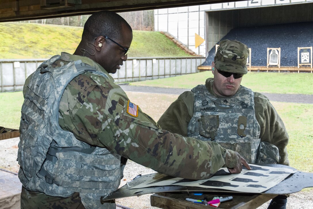 Soldiers examine a shot grouping on a rifle range