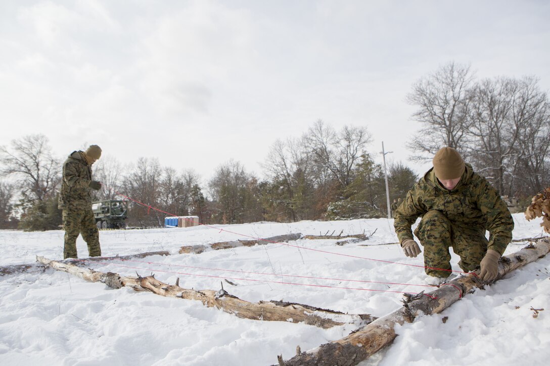 Cpl. Deyton Parker (left), tank mechanic, and Sgt. Soran Shay (right), tank commander, both with Company F, 4th Tank Battalion, 4th Marine Division, create grid lines on a terrain model during exercise Winter Break 2018, Feb. 7, 2018.