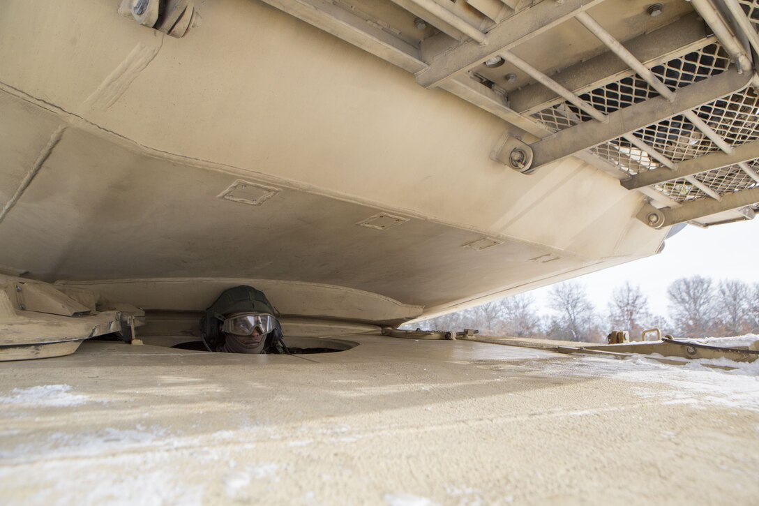 Cpl. Ezra Dawit, a tank driver with Company F, 4th Tank Battalion, 4th Marine Division, waits while his tank is refueled during exercise Winter Break 2018, Feb. 7, 2018.