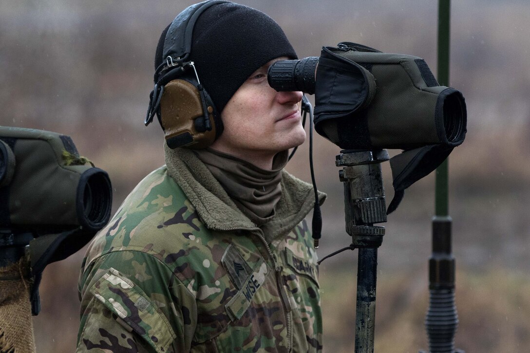 Army Sgt. Cody Wise looks through his spotter scope searching for targets.