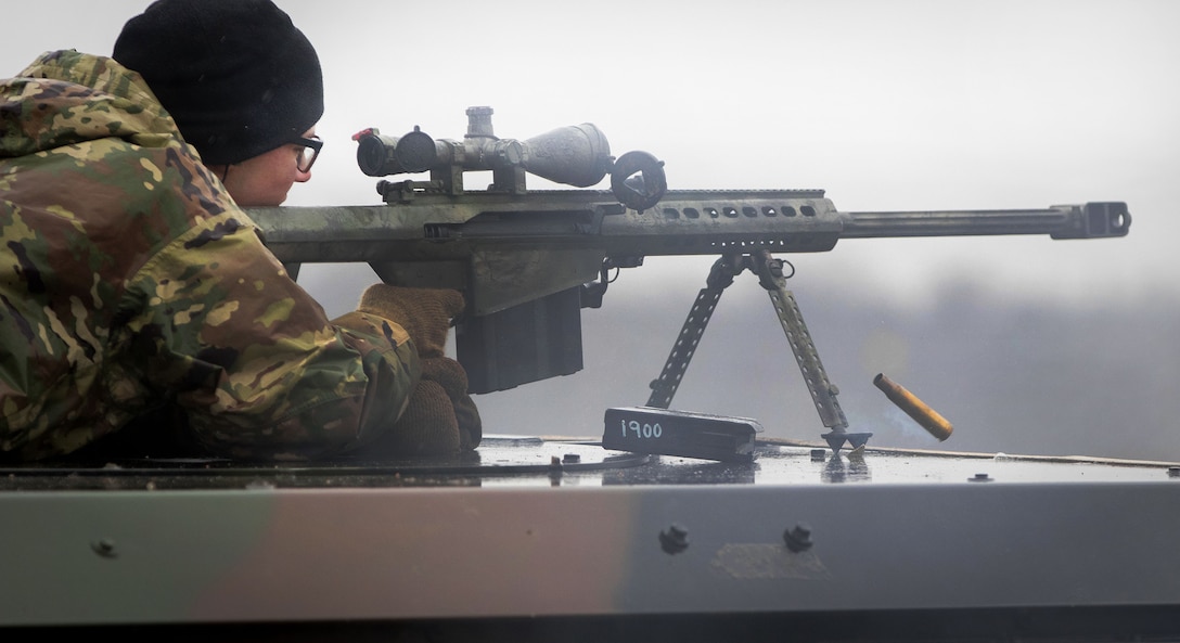 Army Pvt. Jagger Onstott fires his Barrett .50-caliber rifle at targets.