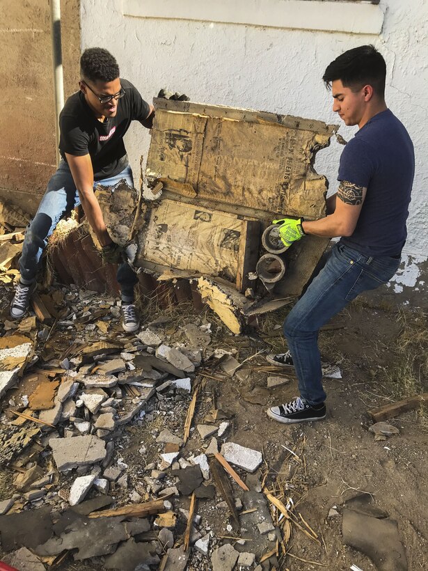 U.S. Marine Corps Cpl. Isaac D. Martinez and Lance Cpl. Joel Soriano, both strategic communication specialists with to Marine Corps Air Station (MCAS) Yuma’s Headquarters & Headquarters Squadron, move a large piece of rubble from a torn-down shed at St. Thomas Yuma Indian Mission in Winterhaven, Calif., Feb. 3, 2018. The mission, located out in the local Yuma community, requested help in tearing down the shed so that renovations could be made to the building. (U.S. Marine Corps photo taken by Cpl. Isaac Martinez)