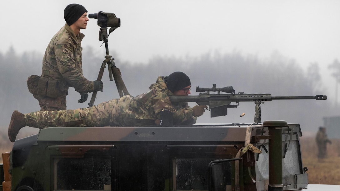 Army Spc. Joseph Swafford, top, spots for targets while Pvt. Jagger Onstott fires his Barrett .50-caliber rifle.