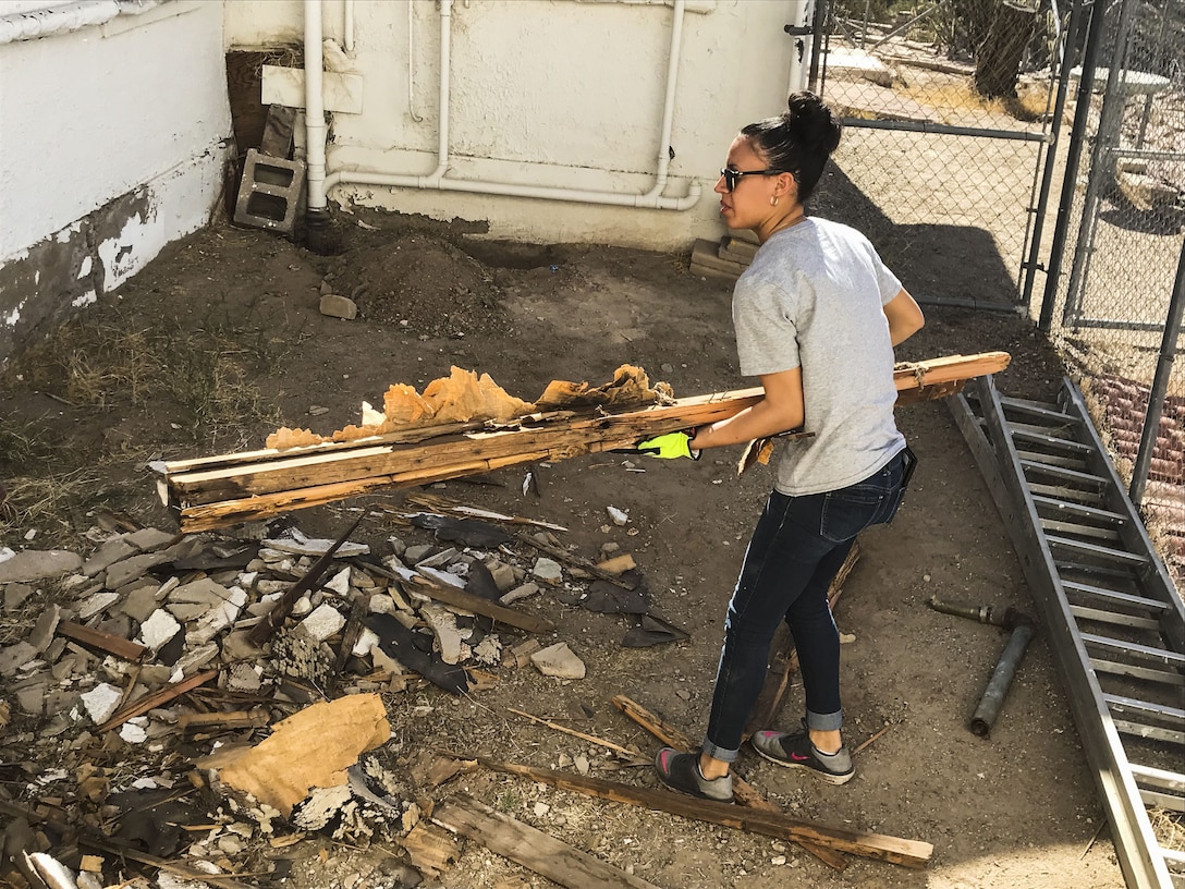 U.S. Marine Corps Lance Cpl. Adriana Adorno, a distribution management specialist assigned to Marine Corps Air Station (MCAS) Yuma’s Headquarters & Headquarters Squadron, lifts rubble from a torn-down shed at St. Thomas Yuma Indian Mission in Winterhaven, Calif., Feb. 3, 2018. The mission, located out in the local Yuma community, requested help in tearing down the shed so that renovations could be made to the building. (U.S. Marine Corps photo taken by Cpl. Isaac Martinez)