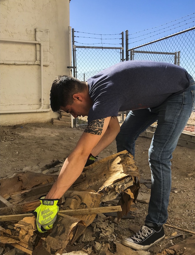 U.S. Marine Corps Lance Cpl. Joel Soriano, a strategic communication specialist assigned to Marine Corps Air Station (MCAS) Yuma’s Headquarters & Headquarters Squadron, lifts rubble from a torn-down shed at St. Thomas Yuma Indian Mission in Winterhaven, Calif., Feb. 3, 2018. The mission, located out in the local Yuma community, requested help in tearing down the shed so that renovations could be made to the building. (U.S. Marine Corps photo taken by Cpl. Isaac Martinez)