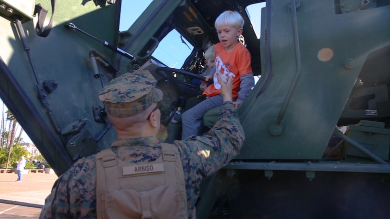Pfc. Jacob Arbiscogautieri, a High Mobility Artillery Rocket System operator, with I Marine Expeditionary Force, helps children down from the cab of a HIMARS vehicle while it is staged prior to the San Diego County Credit Union Holiday Bowl Parade, Dec. 28, 2017. In 2017, I MEF Marines and Sailors supported more than 140 community events.