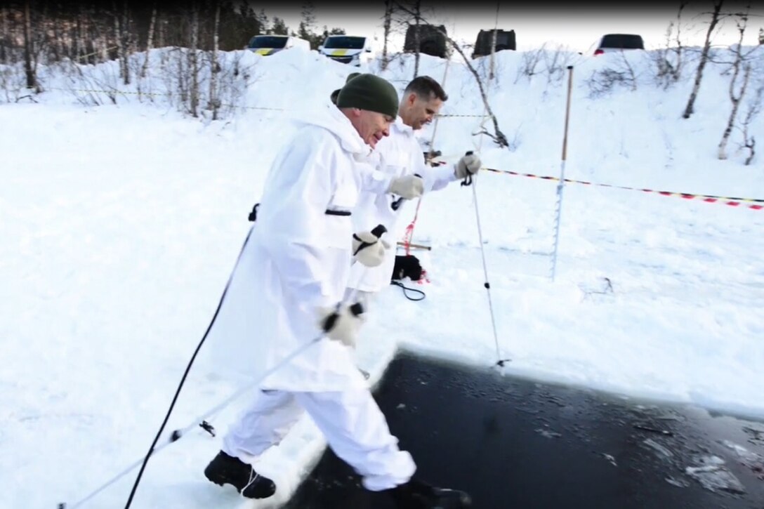 Two men prepare to jump into icy water.