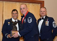Col. Dana Nelson, 507th Air Refueling Wing vice commander, and Chief Master Sgt. David Dickson, 507th ARW command chief, present the 2017 507th ARW Senior Noncommissioned Officer of the Year award to Master Sgt. Ricky Buettner, 507th Security Forces Squadron, Feb. 3, 2018, in Midwest City, Okla. (U.S. Air Force photo/Tech. Sgt. Samantha Mathison)