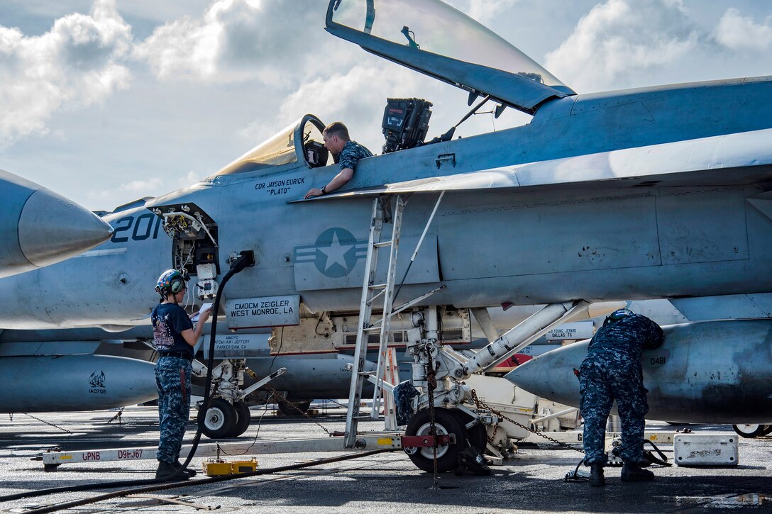 Sailors perform maintenance on an F/A-18E Super Hornet on the flight deck of the aircraft carrier USS Carl Vinson.