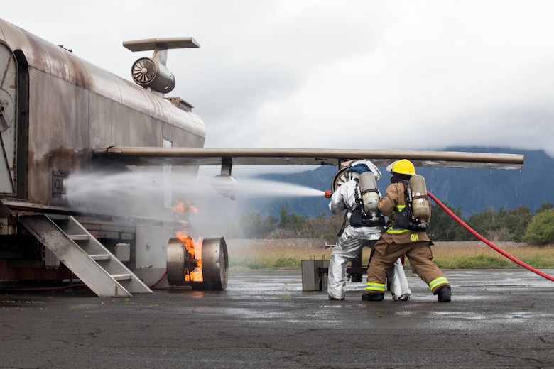 U.S. Marines with Aircraft Rescue Fire Fighting (ARFF) extinguish a wheel fire from a training aircraft during a wheel fire exercise at West Field, Marine Corps Air Station, Feb. 2, 2018. ARFF conducted a wheel fire exercise to improve proficiency in assessing and extinguishing a fire by utilizing the Mobile Aircraft Firefighting Training Device. (U.S. Marine Corps photo by Cpl. Jesus Sepulveda Torres)