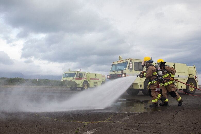 U.S. Marines with Aircraft Rescue Fire Fighting (ARFF) approach a burning training aircraft with fire hoses during a wheel fire exercise at West Field, Marine Corps Air Station, Feb. 2, 2018. ARFF conducted a wheel fire exercise to improve proficiency in assessing and extinguishing a fire by utilizing the Mobile Aircraft Firefighting Training Device. (U.S. Marine Corps photo by Cpl. Jesus Sepulveda Torres)