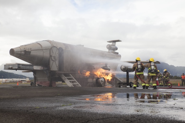 U.S. Marines with Aircraft Rescue Fire Fighting (ARFF), extinguish a live fire from a training aircraft during a wheel fire exercise at West Field, Marine Corps Air Station, Feb. 2, 2018. ARFF conducted a wheel fire exercise to improve proficiency in assessing and extinguishing a fire by utilizing the Mobile Aircraft Firefighting Training Device. (U.S. Marine Corps photo by Cpl. Jesus Sepulveda Torres)