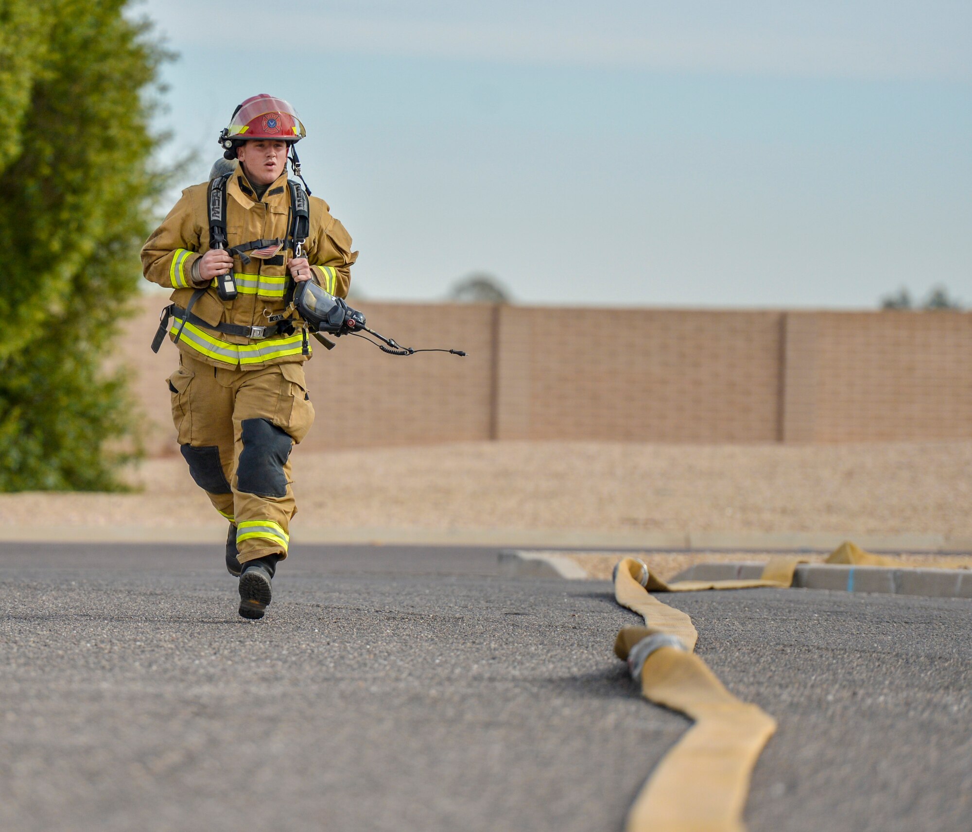 An Airman assigned to the 56th Civil Engineer Squadron runs to the scene of a simulated fire during structural firefighting training at Luke Air Force Base, Ariz., Jan. 16, 2018. Firefighters use hands-on, realistic training scenarios to better prepare them for real-world situations. (U.S. Air Force photo/Airman 1st Class Caleb Worpel)