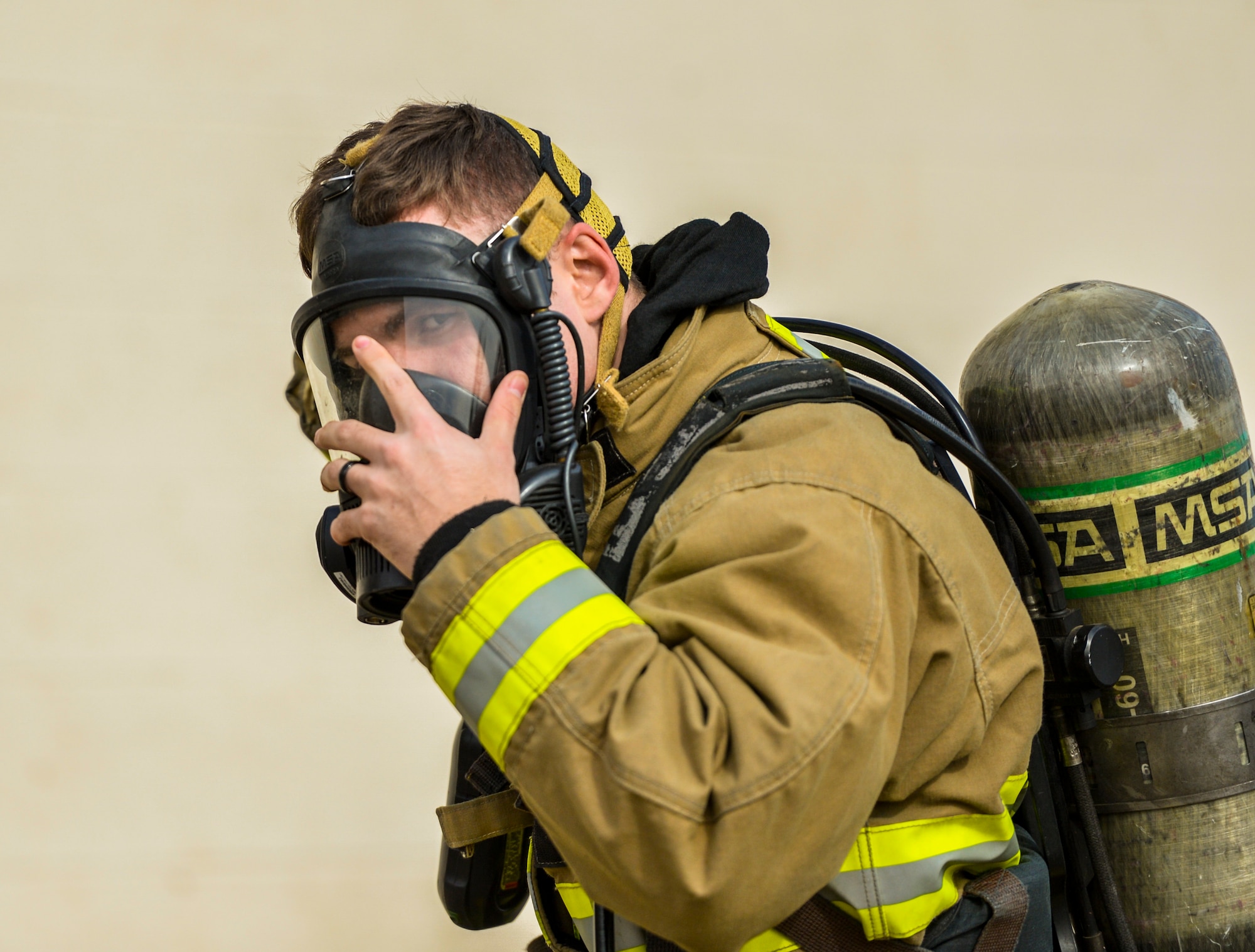 An Airman assigned to the 56th Civil Engineer Squadron puts on an oxygen respirator during structural firefighting training at Luke Air Force Base, Ariz., Jan. 16, 2018. Firefighters use hands-on, realistic training scenarios to better prepare them for real-world situations. (U.S. Air Force photo/Airman 1st Class Caleb Worpel)