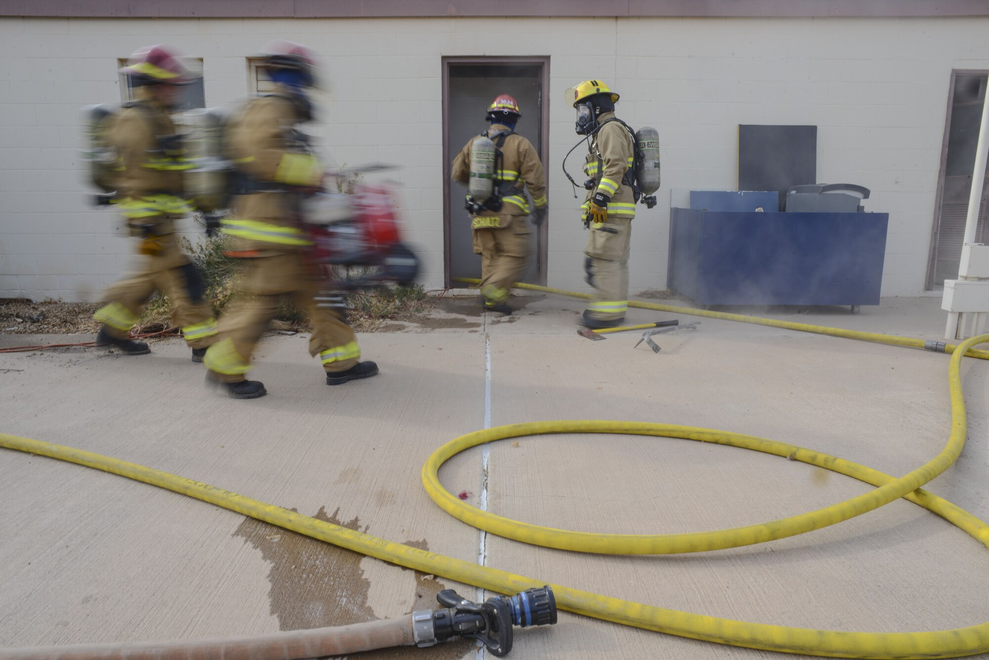 Airmen assigned to the 56th Civil Engineer Squadron enter a building during structural firefighting training at Luke Air Force Base, Ariz., Jan. 16, 2018. The goal of the training was to clear heat and smoke from a contained structure to increase chances of survival for occupants trapped inside. (U.S. Air Force photo/Airman 1st Class Caleb Worpel)