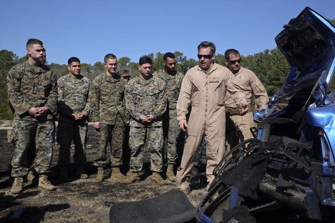 A Marine Corps instructor shows Marines and sailors the remains of a car after an explosion.