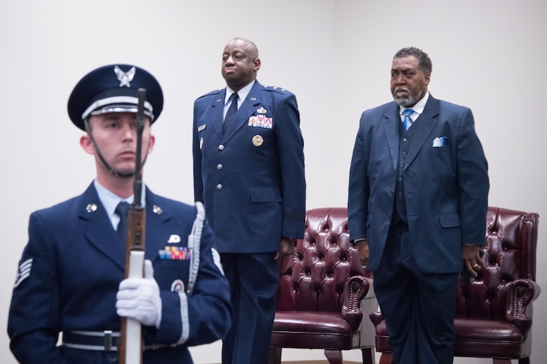 Maj. Gen. Mark Brown, Air Education and Training Command deputy commander, and Gary Wallace, 53rd Weather Reconnaissance Squadron aviation resource management technician, stand at attention while members of the Keesler Honor Guard present the colors for Wallace's retirement ceremony Feb. 2, 2018 at Keesler Air Force Base, Mississippi. (U.S. Air Force photo by Staff Sgt. Heather Heiney)