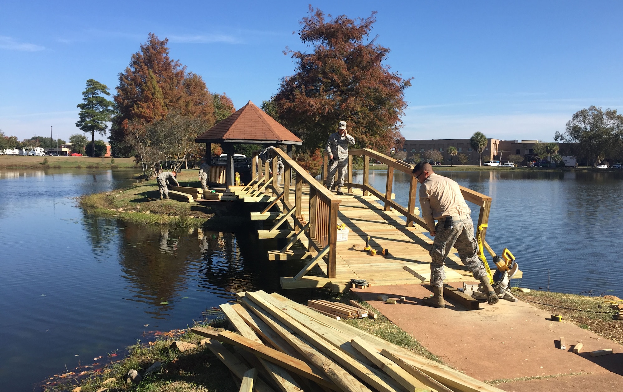 Volunteers work to restore the bridge at Memorial Lake at Shaw Air Force Base, S.C., Nov. 15, 2017.