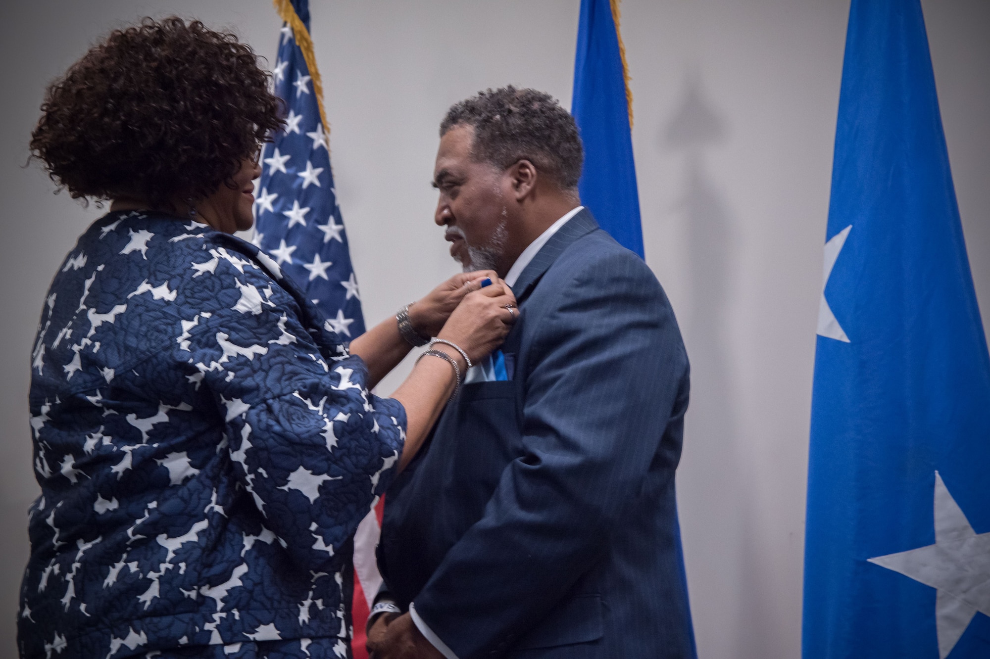 Yolanda Wallace places a retirement pin on the lapel of her husband, Gary Wallace, 53rd Weather Reconnaissance Squadron aviation resources management technician, during his retirement ceremony Feb. 2, 2018 at Keesler Air Force Base, Mississippi. (U.S. Air Force photo by Staff Sgt. Heather Heiney)