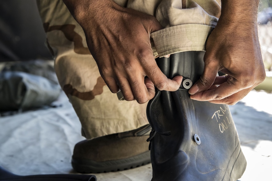 Tech Sgt. Kendrick Butler, 23d Maintenance Squadron assistant NCO in charge of aircraft metals technology, tightens his boots, Feb. 1, 2018, at Moody Air Force Base, Ga. Airmen participated in a chemical, biological, radiological and nuclear defense (CBRNE) class to better prepare them to combat enemy attacks while also familiarizing them with mission-oriented protective posture (MOPP) gear. (Air Force photo by Airman Eugene Oliver)