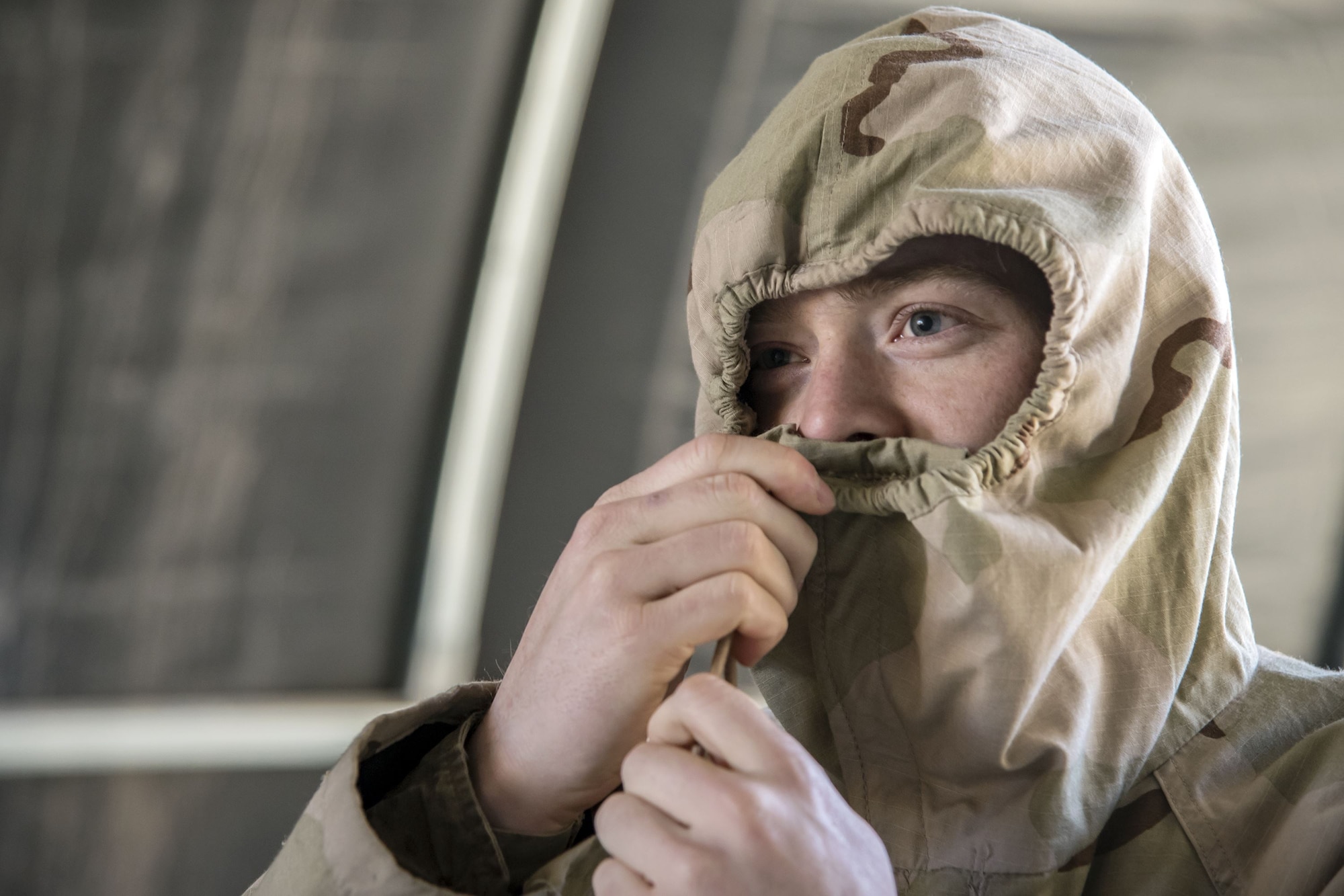 Senior Airman Collin Chase, 23d Maintenance Squadron aircraft fuels systems journeyman, tightens the barrel locks on the hood of his overcoat, Feb. 1, 2018, at Moody Air Force Base, Ga. Airmen participated in a chemical, biological, radiological and nuclear defense (CBRNE) class to better prepare them to combat enemy attacks while also familiarizing them with mission-oriented protective posture (MOPP) gear. (Air Force photo by Airman Eugene Oliver)
