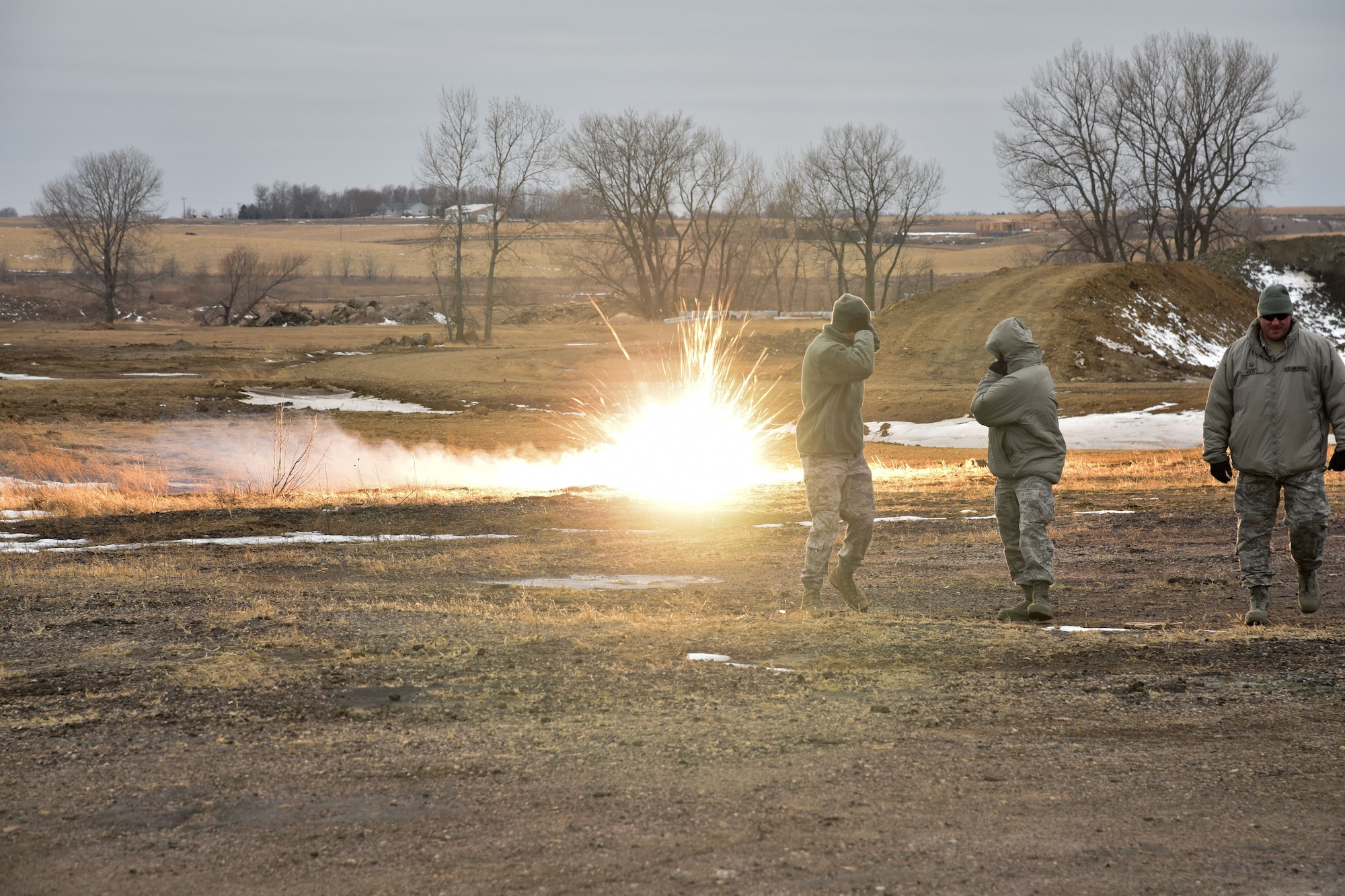 114th Security Forces Squadron members deploy ground burst simulators during training at a range near Joe Foss Field, S.D. Feb. 3, 2018.