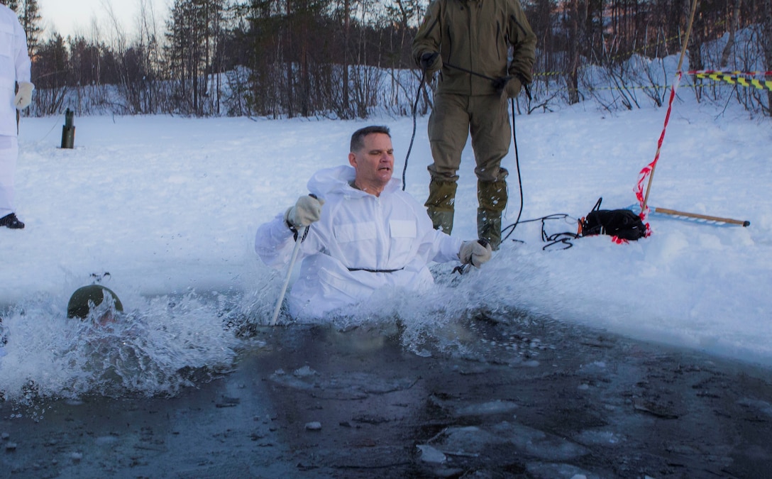 Norwegian Maj.Gen. Odin Johannessen, the chief of Norwegian Army, participates in an ice-breaking drill alongside Maj.Gen. Russell A.C. Sanborn, the commander of Marine Corps Forces Europe and Africa, in Bardufoss, Norway, Jan. 31, 2018. Sanborn participated in this training evolution to experience the training the Marines have endured throughout their time in Norway. The drill is a cornerstone of advanced cold-weather training, intended to teach a service member the immediate steps to take when falling in ice.  (U.S. Marine Corps photo by Cpl. Careaf L. Henson/Released)