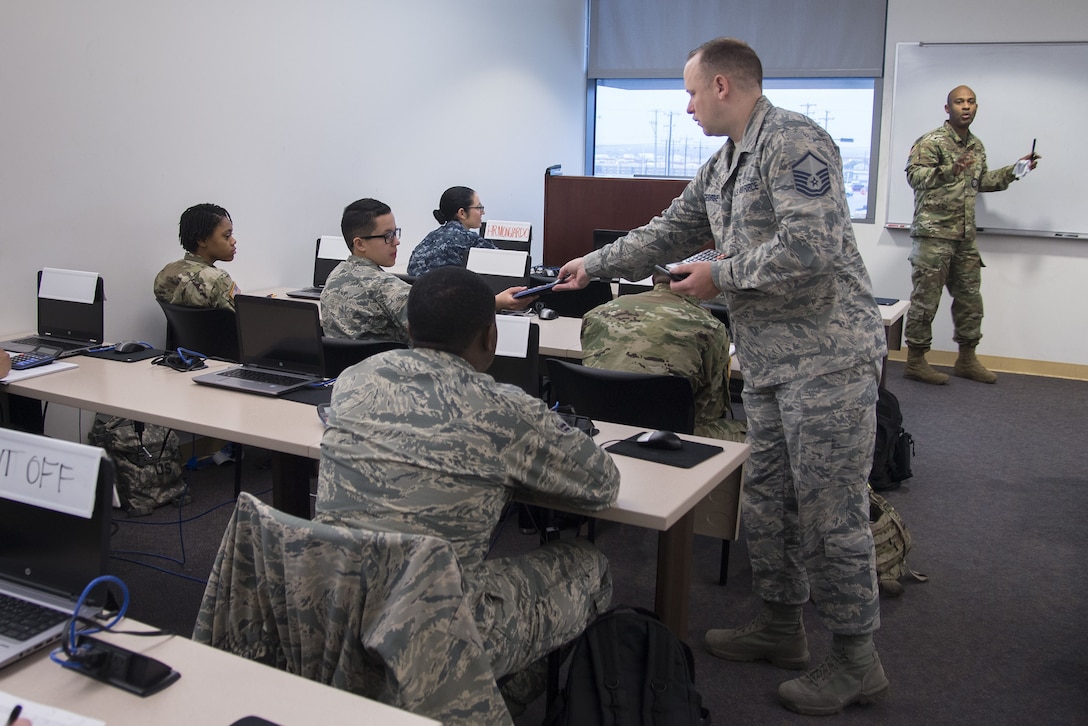 Master Sgt. Robert George, Medical Education & Training Campus pharmacy training senior enlisted leader, hands out calculators to students prior to an examination Feb. 5 at Joint Base San Antonio-Fort Sam Houston. The Department of Defense’s pharmacy technician program prepares students to perform both inpatient and outpatient pharmacy operations in both traditional and non-traditional pharmacy practices.