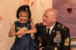 1st Sgt. Joseph Bierbrodt of Sheridan, Illinois, with the 933rd Military Police Company, smiles at Cayleigh Hinton just before escorting her into the father-daughter dance at the Our Lady of Humility School in Beach Park, Illinois