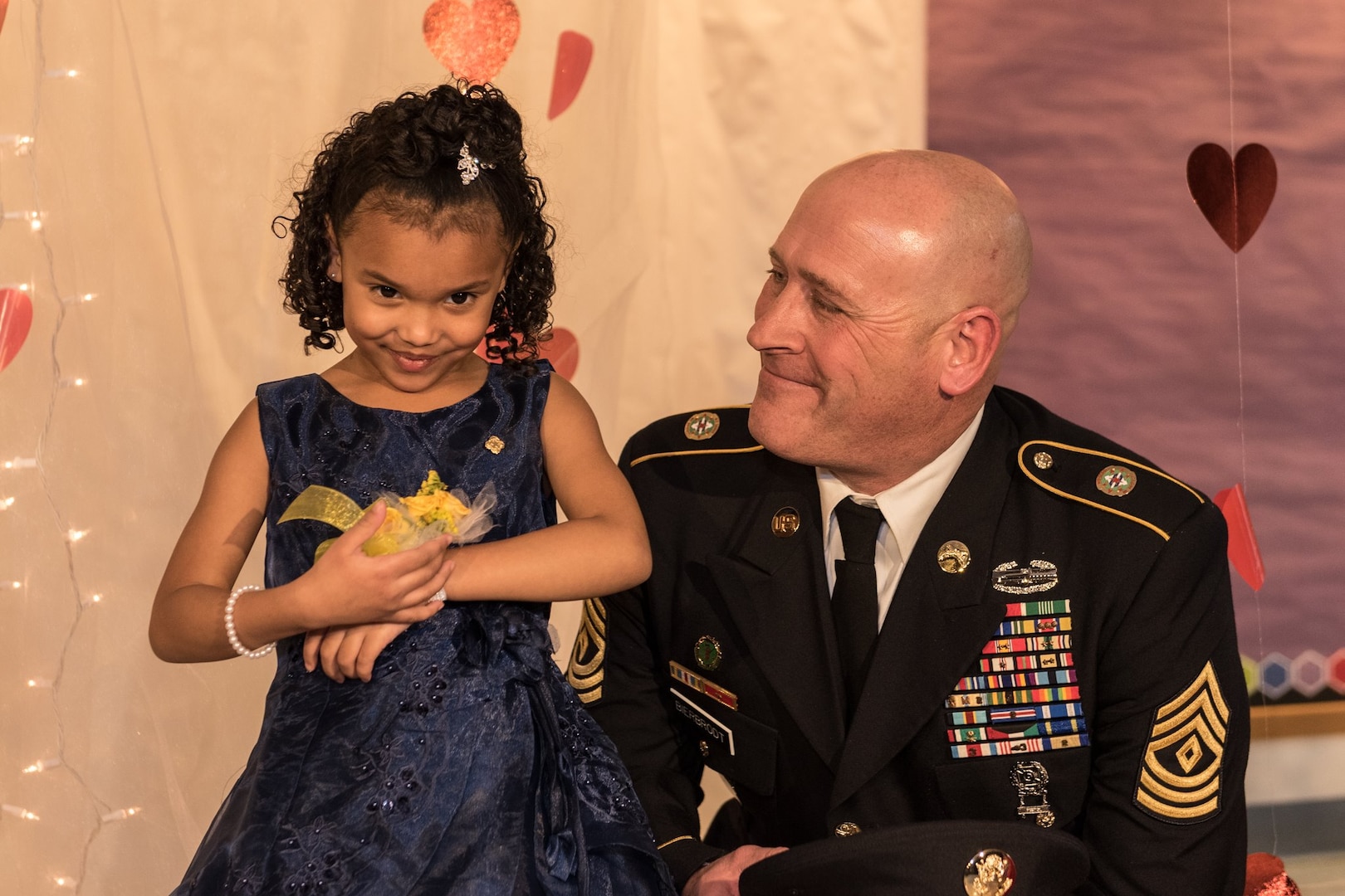 1st Sgt. Joseph Bierbrodt of Sheridan, Illinois, with the 933rd Military Police Company, smiles at Cayleigh Hinton just before escorting her into the father-daughter dance at the Our Lady of Humility School in Beach Park, Illinois