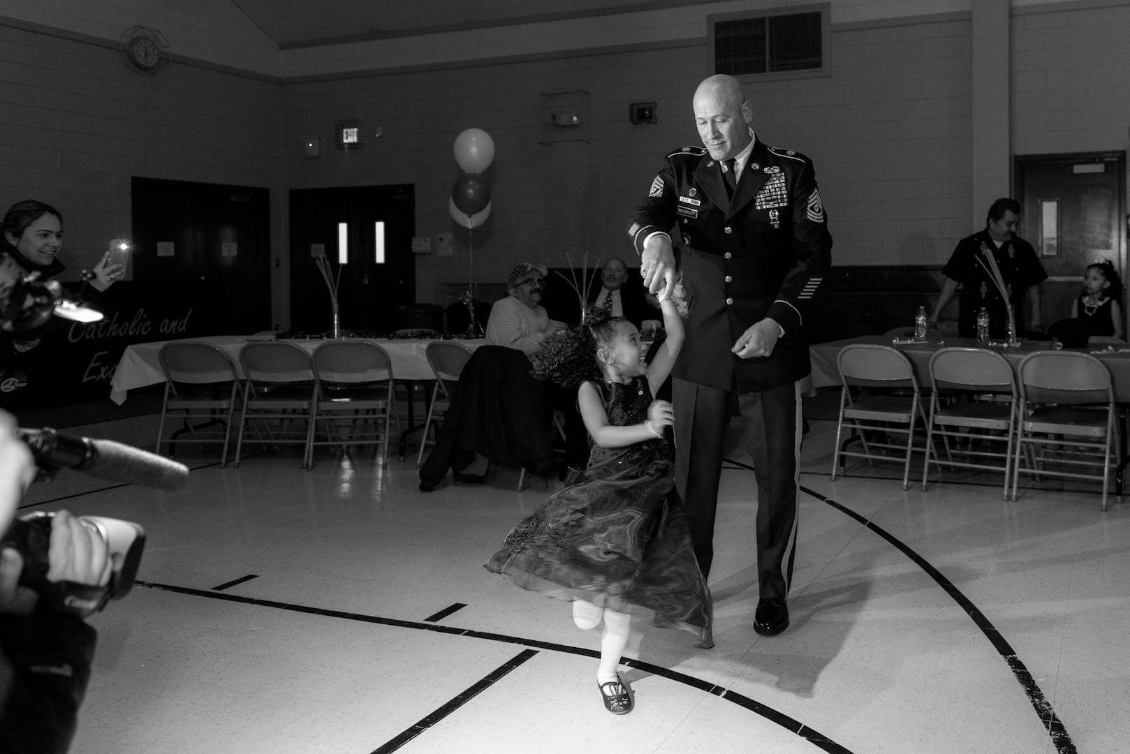 Cayleigh Hinton, daughter of Sgt. Terrence Hinton, dances with 1st Sgt. Joseph Bierbrodt of Sheridan, Illinois, with the 933rd Military Police Company, Feb. 7, at a father-daughter dance held at the Our Lady of Humility School in Beach Park, Illinois.