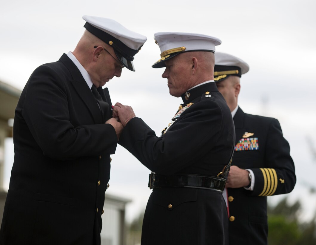 Lt. Gen. Lawrence D. Nicholson, the III Marine Expeditionary Force commanding general, awards the Legion of Merit to III MEF Command Master Chief Petty Officer Michael J. Fasano during his retirement ceremony at Marine Corps Air Station Futenma, Okinawa, Japan, Feb. 9, 2018. Fasano, a native of Mobile, Alabama, worked closely with Nicholson as one of his senior enlisted advisors during the final years of his military career. (U.S. Marine Corps photo by Pfc. Hannah Hall)