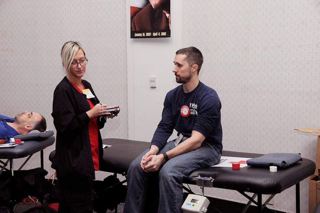 A Red Cross worker assists a donor at the Feb. 7 blood drive at the Hart-Dole-Inouye Federal Center.