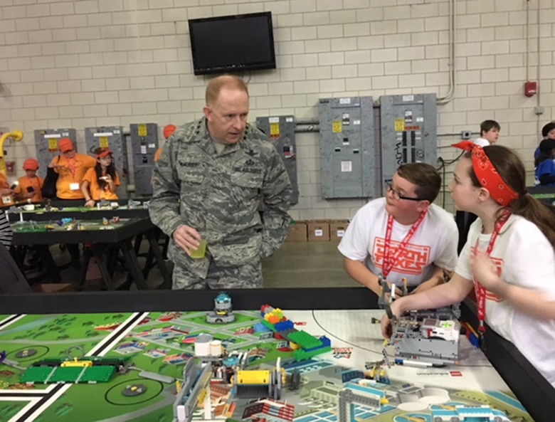 Two participants from Beavercreek explain the For Inspiration and Recognition of Science and Technology (FIRST) LEGO League Ohio Championship competition, held Feb. 4 at Wright State University, to Lt. Gen. Robert McMurry, Air Force Life Cycle Management Center commander, Wright-Patterson Air Force Base. (U.S. Air Force photo/Marie Vanover)