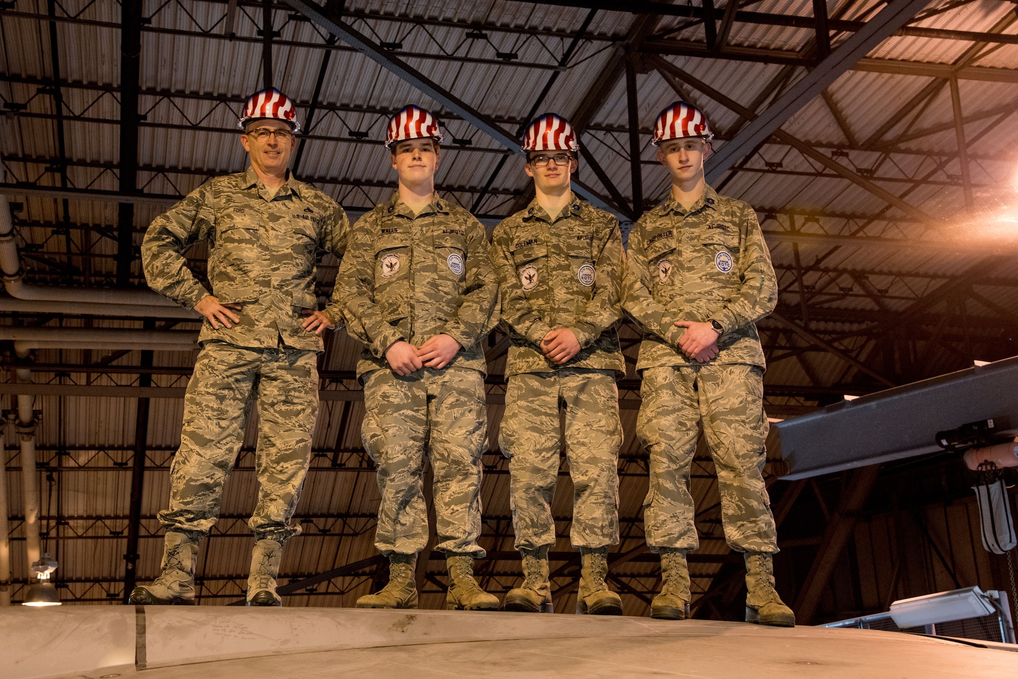 Chief Master Sgt. Bryan Ford, 512th Maintenance Squadron superintendent, and Polytech High School Junior ROTC cadets pose for a photo on the T-tail of a C-5M Super Galaxy aircraft Jan. 30, 2018, inside the Isochronal Maintenance Dock on Dover Air Force Base, Del. The three cadets visited Dover AFB for a two-hour tour of the aircraft maintenance complex. (U.S. Air Force photo by Senior Airman Damien Taylor)