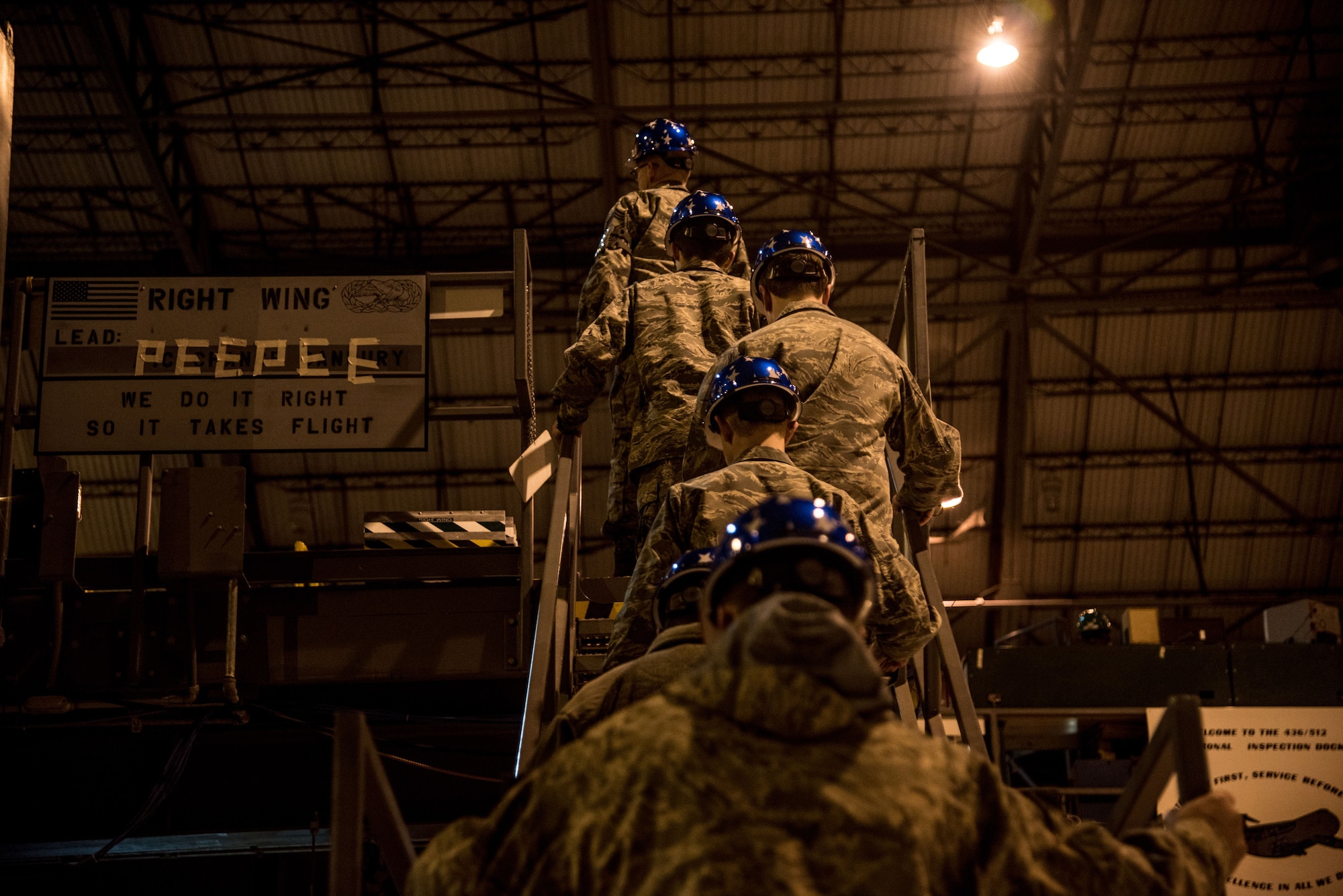 Chief Master Sgt. Bryan Ford, 512th Maintenance Squadron superintendent, and Polytech High School Junior ROTC cadets climb a staircase to the top of a C-5M Super Galaxy’s wings Jan. 30, 2018, at the Isochronal Maintenance Dock on Dover Air Force Base, Del. The cadets toured the facilities to gain a better understanding of the maintenance mission and the Air Force. (U.S. Air Force photo by Senior Airman Damien Taylor)